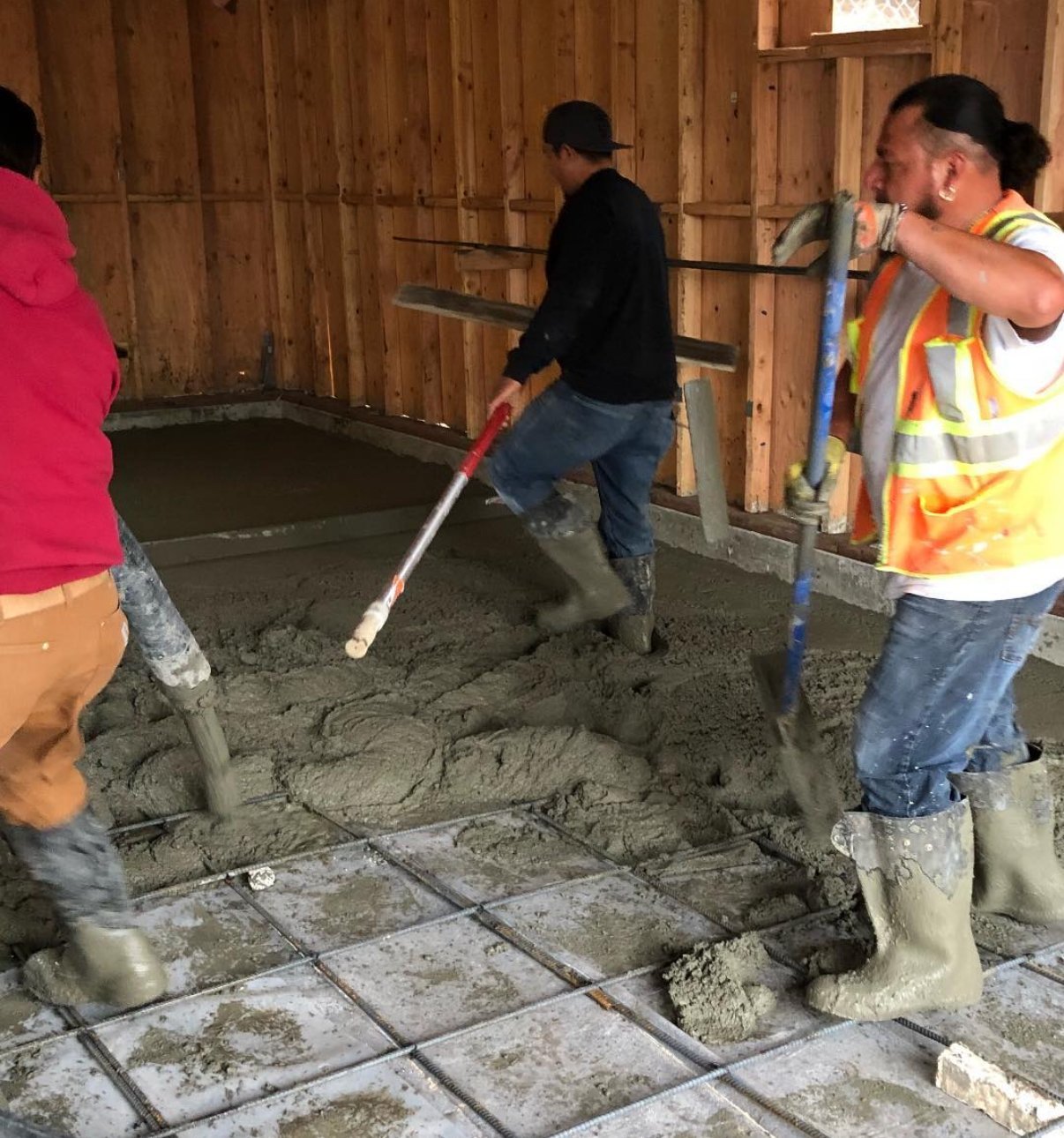 Crew pouring a concrete slab on an Oakland job site